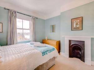a bedroom with a bed and a fireplace at 4 Bed in East Cowes 88655 in East Cowes