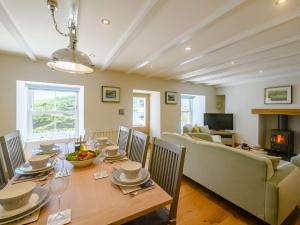 a dining room with a table and a couch at 3 Bed in Portloe 87260 in Portloe