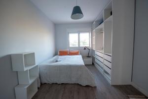 a white bedroom with a bed and a window at Habitaciones Privadas en mi acogedor Chalet - Private rooms in Madrid