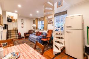 a kitchen with a refrigerator and a living room at Character Cottage In Historic Hampstead in London