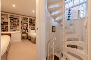 a white staircase in a room with a bedroom at Character Cottage In Historic Hampstead in London