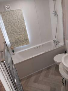 a bathroom with a tub and a toilet and a sink at Riverside terrace - Overlooking the nature reserve in Rye Harbour