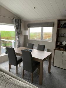 a dining room with a wooden table and chairs at Riverside terrace - Overlooking the nature reserve in Rye Harbour