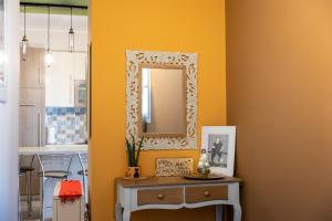 a yellow room with a mirror and a table at Art House in Drama