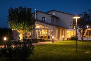 a house with lights on the lawn at night at Locanda Borgognina in Lucrezia