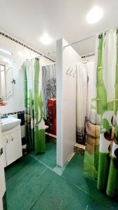 a bathroom with a sink and a shower with green floors at Hostel Amazing Ionika CenterCity in Chişinău