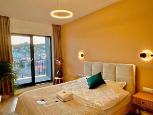 ein Schlafzimmer mit einem großen Bett und einem großen Fenster in der Unterkunft Golden beryl - Selestate in Braşov