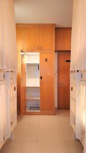 uma cozinha com armários de madeira e um armário vazio em WeStay Ladies Hostel em Dubai