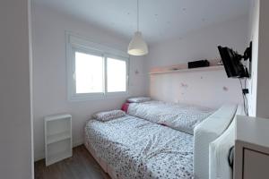 um pequeno quarto com 2 camas e uma janela em Habitaciones Privadas en mi acogedor Chalet - Private rooms em Madri