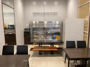 a restaurant with a refrigerator and tables and chairs at dpCristal in Sarria