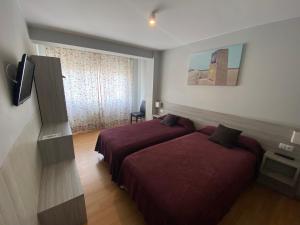 Habitación de hotel con 2 camas y ventana en dpCristal en Sarria