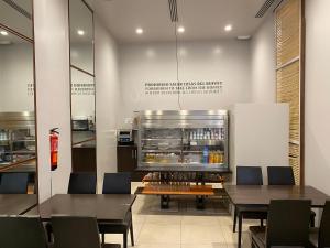ein Restaurant mit Tischen, Stühlen und einem Kühlschrank in der Unterkunft dpCristal in Sarria