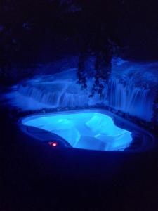 a hot tub in front of a waterfall at night at ZAJAZD ALBATROS Rzeszow in Rzeszów