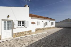 a white house with a cobblestone street at White House by AcasaDasCasas in Mafra