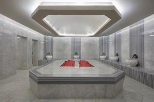 une grande chambre avec des tapis rouges au milieu dans l'établissement Aydinbey Queen’s Palace & SPA, à Belek