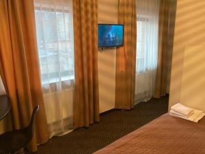 a hotel room with a tv on the wall and curtains at Міні-готель Тремпель in Kharkiv