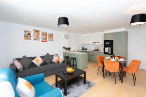 sala de estar y cocina con sofá y mesa en Watford Cassio Supreme - Modernview Serviced Accommodation en Watford