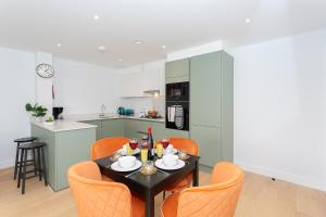 a dining room with a table and orange chairs at Watford Cassio Supreme - Modernview Serviced Accommodation in Watford