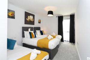 1 dormitorio con 2 camas y ventana en Watford Cassio Supreme - Modernview Serviced Accommodation en Watford