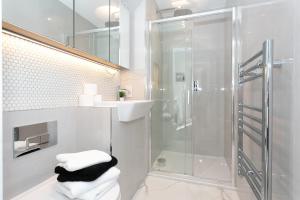 uma casa de banho com um chuveiro, um lavatório e toalhas em Watford Cassio Supreme - Modernview Serviced Accommodation em Watford