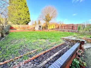 a backyard with a fence and a garden withgrass at Sapphire Family Ensuite XL Room near QE & UOB in Birmingham