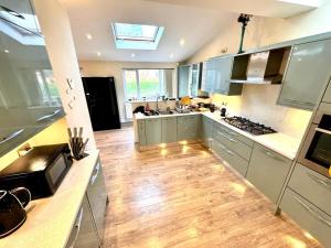 a kitchen with stainless steel appliances and a wooden floor at Sapphire Family Ensuite XL Room near QE & UOB in Birmingham