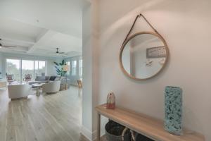 a living room with a mirror on the wall at Ibis At The Sanctuary A302 in Sanibel