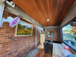 a brick walled room with a sink and a window at Jineng Guest house by the swand in Dalung