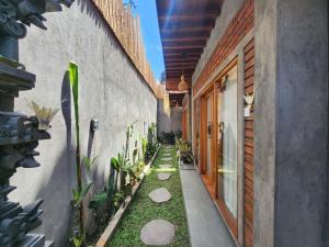 a walkway between two buildings with plants at Jineng Guest house by the swand in Dalung