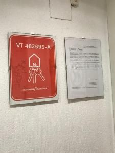 a red sign hanging on a wall next to a paper at Piso turístico completo La Gimena in Orihuela