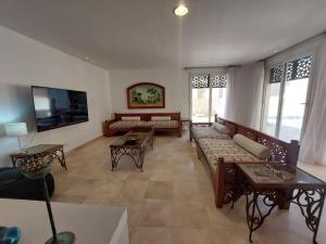a living room with couches and tables and windows at Nayah Boutique Stays in Hurghada