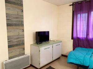 Apartamentos La Cabaneta Mikka Sky 3000 في باس دي لا كاسا: غرفة مع تلفزيون في أعلى خزانة مع جهاز تلفاز