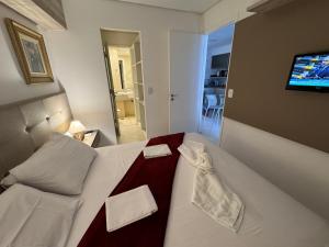 1 dormitorio con 1 cama blanca grande y TV de pantalla plana en Landscape Beira Mar, Lindo, Luxo, Vista mar en Fortaleza