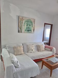 a living room with a couch and a statue of a head at Bonito Apartamento California 6 in Miami Platja