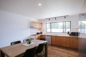 a kitchen with a wooden table and a dining room at Red Door On Cade in Yarrawonga