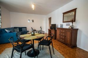 un soggiorno con tavolo, sedie e divano blu di Marynia by Rentoom a Toruń Altre 11 foto