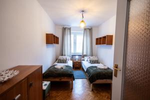 una piccola stanza con due letti e un tavolo di Marynia by Rentoom a Toruń