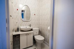 un bagno con un water, un lavandino e uno specchio di Marynia by Rentoom a Toruń