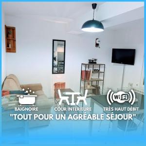 sala de estar con cama y TV en Dom Pérignon - Appartement en centre-ville., en Sainte-Menehould