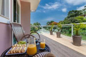 einen Tisch mit Orangensaft und Obst auf dem Balkon in der Unterkunft NStudio Itaipuaçu - Garagem Privativa - Localizado a 1000m da praia in Maricá