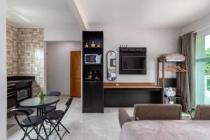 a kitchen and living room with a table and chairs at Studio completo com ar, garagem e varanda espaçosa em Itaipuaçu - Ideal para 3 pessoas in Maricá