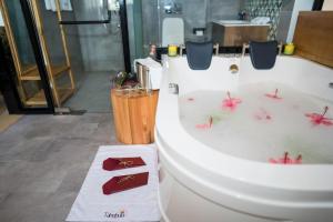 een badkamer met een bad met roze bloemen bij Tabebuia Spa and Safari Resort in Fort Portal