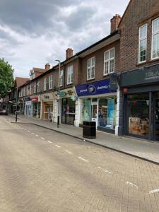 an empty street with shops on the side of the road at Remarkable 1-Bed Apartment in Putney Village in London