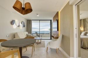 a living room with a dining room table and a bedroom at RELAXIA BEVERLY SUITES in Playa del Ingles