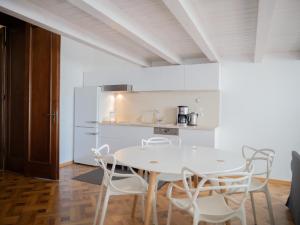 a white kitchen with a white table and chairs at Casa Mandl in Braşov