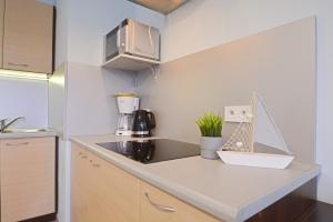 een kleine keuken met een aanrecht en een magnetron bij Osiedle Platan - Apartamenty Bryza - Centrum in Świnoujście +282 foto's