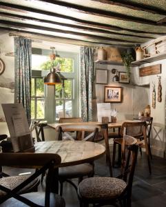 ein Esszimmer mit Tischen, Stühlen und einem Fenster in der Unterkunft Wateredge Inn- The Inn Collection Group in Ambleside