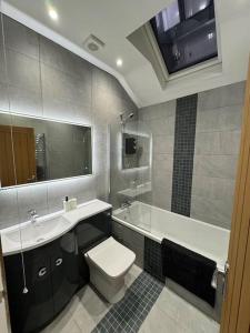 a bathroom with a toilet and a sink and a tub at Jasmine Cottage, Newbiggin by the sea in Woodhorn