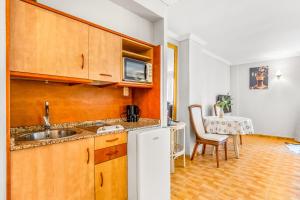 a kitchen with a sink and a table at Unique Apartahotel 3-2 in Torrevieja