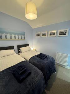 a bedroom with two beds with towels on them at Jasmine Cottage, Newbiggin by the sea in Woodhorn